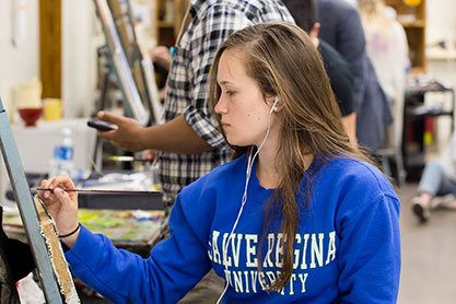 A student painting in art class. Links to Donor-Advised Funds
